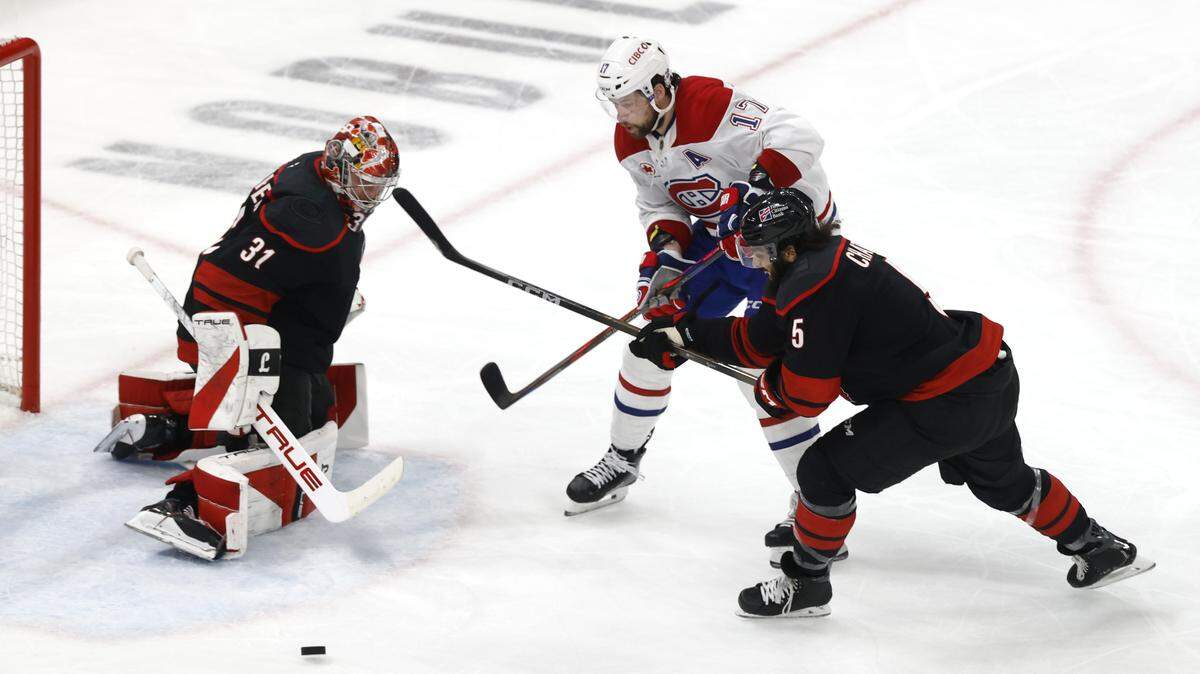 Carolina's Frederik Andersen (31) keeps his eye on the puck as Carolina's Jalen Chatfield (5) and Montréal's Josh Anderson (17) battle during the second period of the Hurricanes’ game against the Canadiens in game one of the Eastern Conference Finals at the Lenovo Center Thursday, May, 21, 2026.