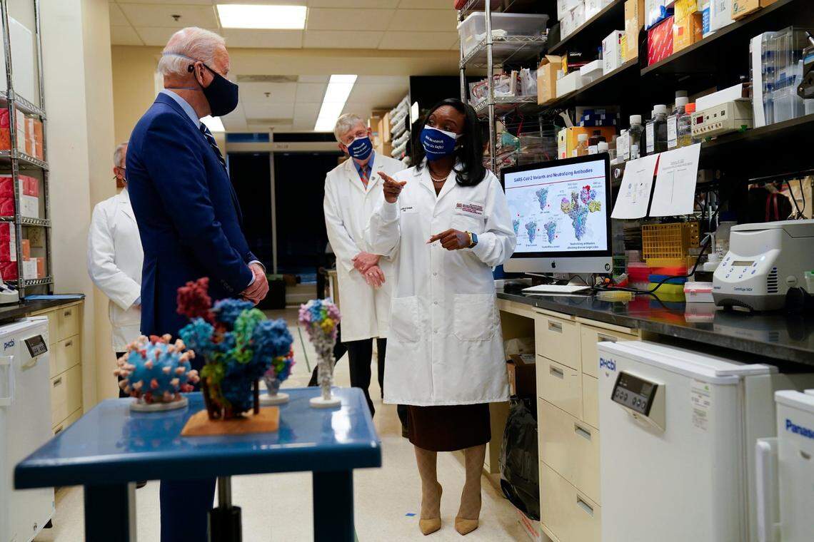 President Joe Biden listens as Kizzmekia Corbett speaks during a visit at the Viral Pathogenesis Laboratory at the National Institutes of Health, Thursday, Feb. 11, 2021, in Bethesda, Md. Dr. Anthony Fauci, director of the National Institute of Allergy and Infectious Diseases, and Francis Collins, National Institutes of Health Director listen.