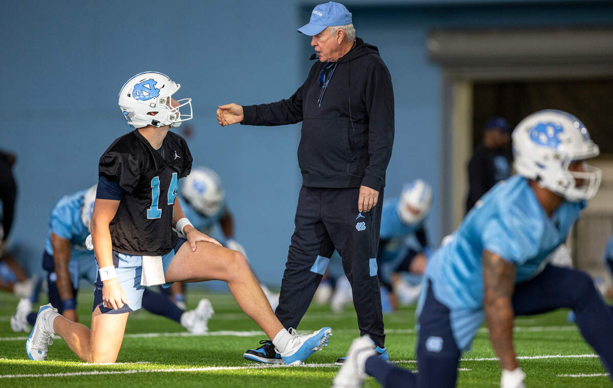 North Carolina coach Mack Brown talks with graduate transfer quarterback Max Johnson (14) during the opening day of their spring football practice on Tuesday, March 19, 2024 in Chapel Hill, N.C.