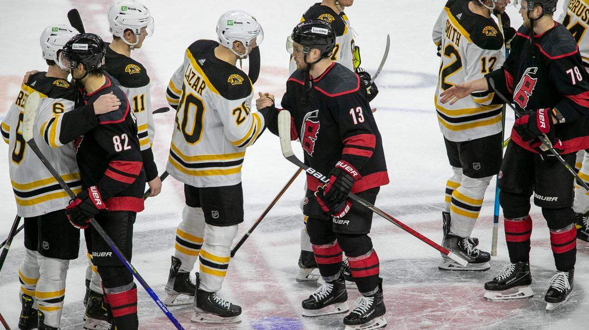 The Carolina Hurricanes Max Domi (13) shakes hands with Boston Bruins Curtis Lazar (20) following their 3-2 victory over Boston, clinching the first round of their Stanley Cup series on Saturday, May 14, 2022 at PNC Arena in Raleigh, N.C.