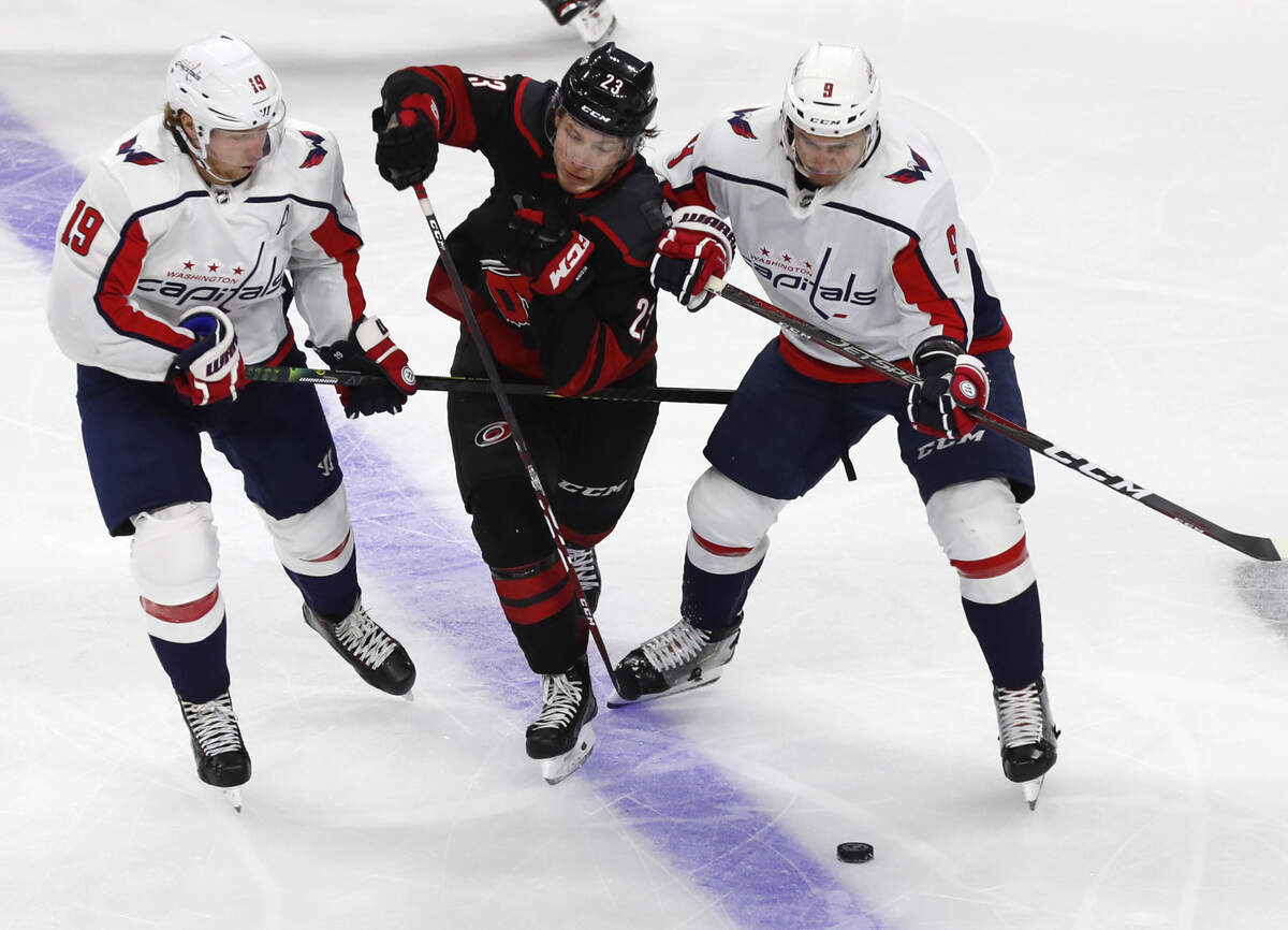 Carolina’s Brock McGinn (23) tries to split the defense of Washington’s Nicklas Backstrom (19) and Dmitry Orlov (9) during the second period of the Carolina Hurricanes’ game against the Washington Capitals at PNC Arena in Raleigh, N.C., Monday, April 22, 2019.