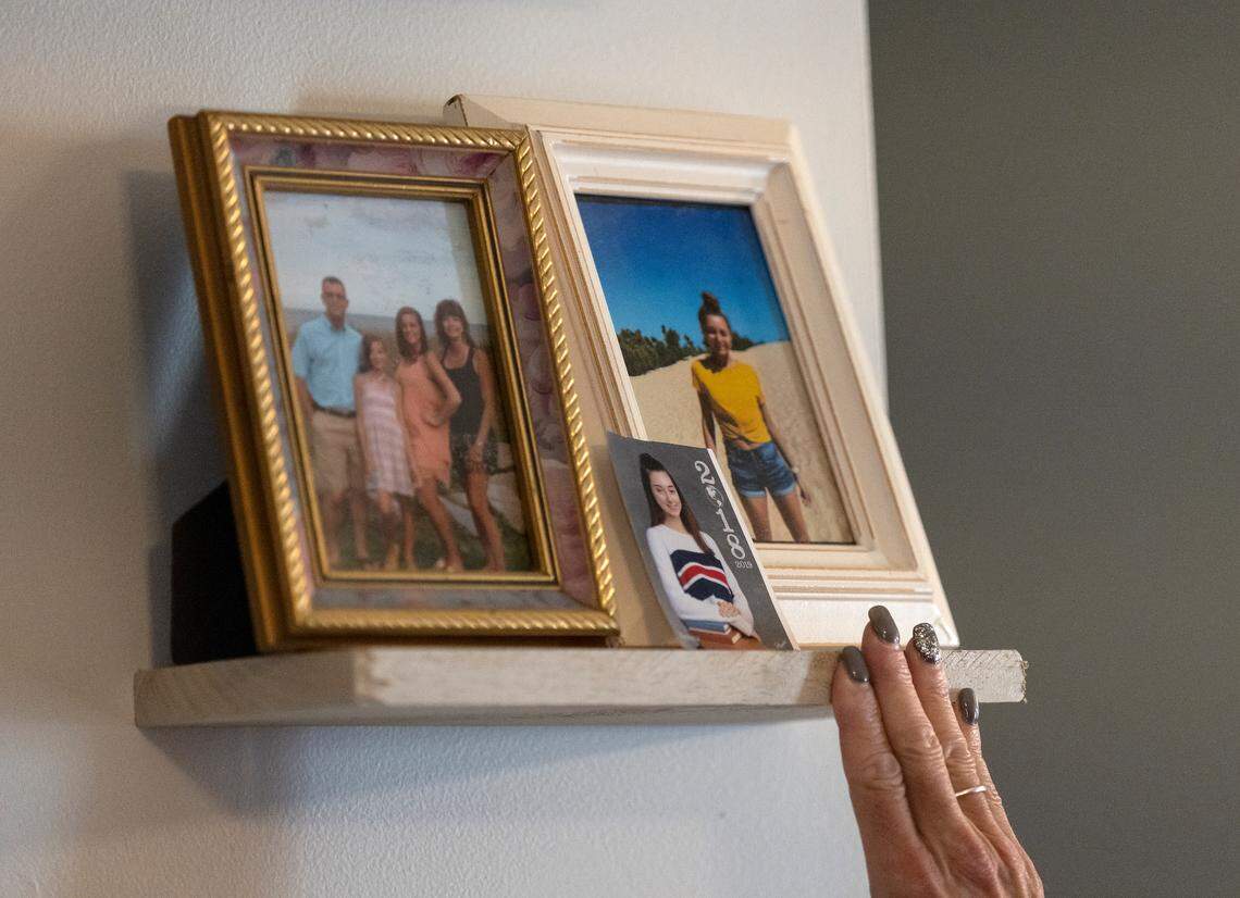 Laura Baker pauses next to photos of her deceased daughter, Veronica, at her home in Raleigh.