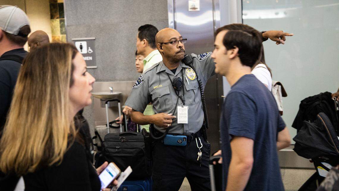 A police officer directs passengers to the end of a security line that stretches around the entire perimeter of the Terminal 2 concourse at Raleigh Durham International Airport at around 6 a.m. on Thursday, June 13, 2019. The crowds are a result of the airport’s success in luring new airlines and new flights.