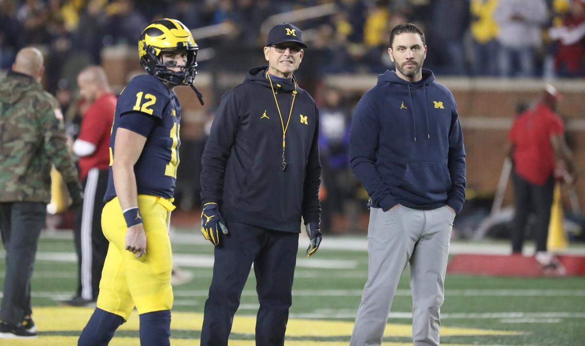 Michigan Wolverines head coach Jim Harbaugh, center, quarterbacks coach Matt Weiss, right, and quarterback Cade McNamara look on during warmups before their game against the Indiana Hoosiers in Nov. 2021 at Michigan Stadium.