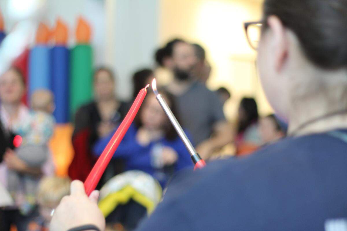 A worshiper lights the menorah at Jewish for Good’s 2019 Hanukkah Festival.