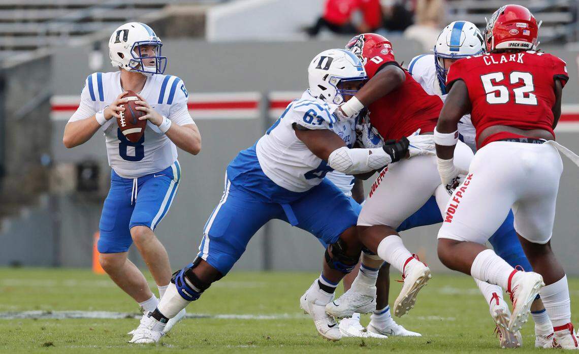 Duke guard Jacob Monk (63), center, blocks N.C. State defensive end Terrell Dawkins (0) as quarterback Chase Brice (8) looks downfield for receivers during the Wolfpack’s game against the Blue Devils at Carter-Finley Stadium in Raleigh, N.C., Saturday, Oct. 17, 2020.