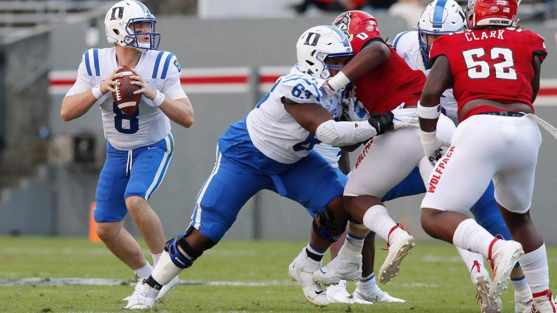 Duke guard Jacob Monk (63), center, blocks N.C. State defensive end Terrell Dawkins (0) as quarterback Chase Brice (8) looks downfield for receivers during the Wolfpack’s game against the Blue Devils at Carter-Finley Stadium in Raleigh, N.C., Saturday, Oct. 17, 2020.