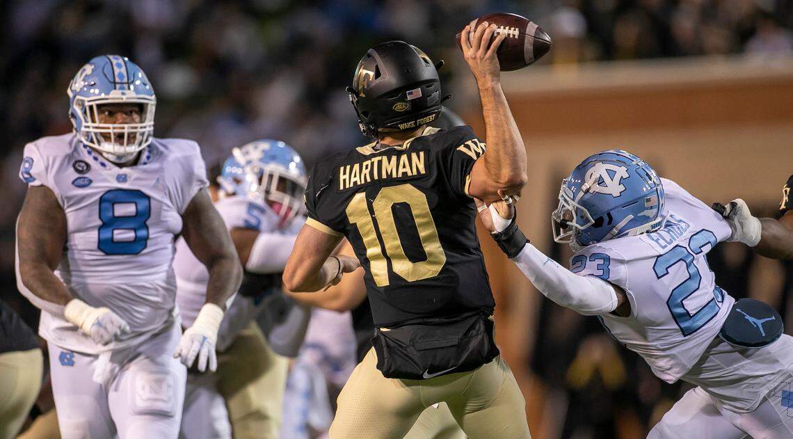 Wake Forest quarterback Sam Hartman (10) is pressured by North Carolina’s Power Echols (23) in the first quarter on Saturday, November 12, 2022 at Truist Field in Winston-Salem, N.C.