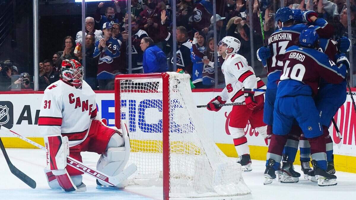 Colorado Avalanche center Nathan McKinnon, obscured, is congratulated by teammates after scoring against Carolina Hurricanes goaltender Frederik Andersen (31) during the third period of an NHL hockey game Saturday, April 16, 2022, in Denver. (AP Photo/Jack Dempsey)