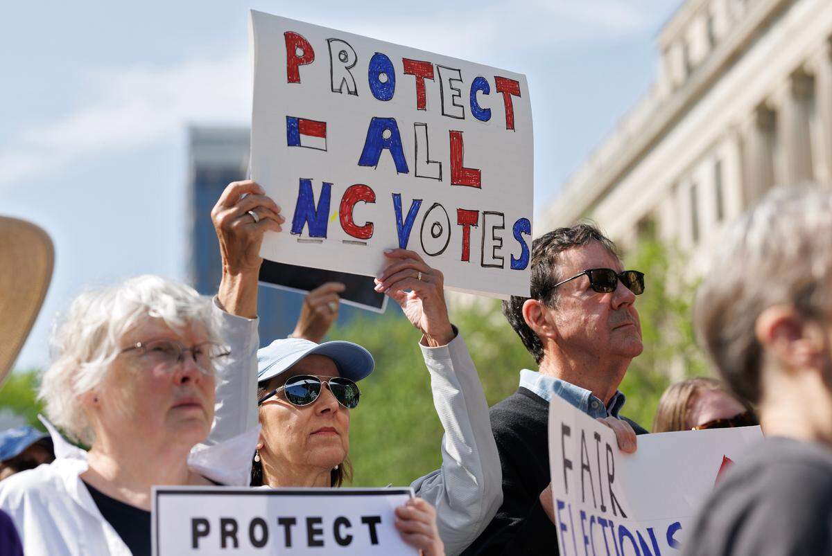 People hold signs during a rally on Monday, April 14, 2025, in Raleigh, N.C., held in protest of Republican state Supreme Court candidate Jefferson Griffin’s challenge of 65,000 votes in the November election.