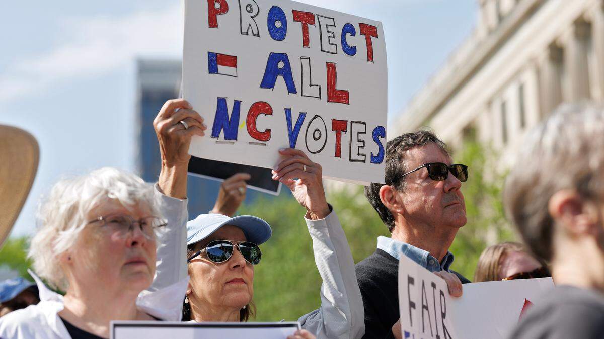 People hold signs during a rally on Monday, April 14, 2025, in Raleigh, N.C., held in protest of Republican state Supreme Court candidate Jefferson Griffin’s challenge of 65,000 votes in the November election.