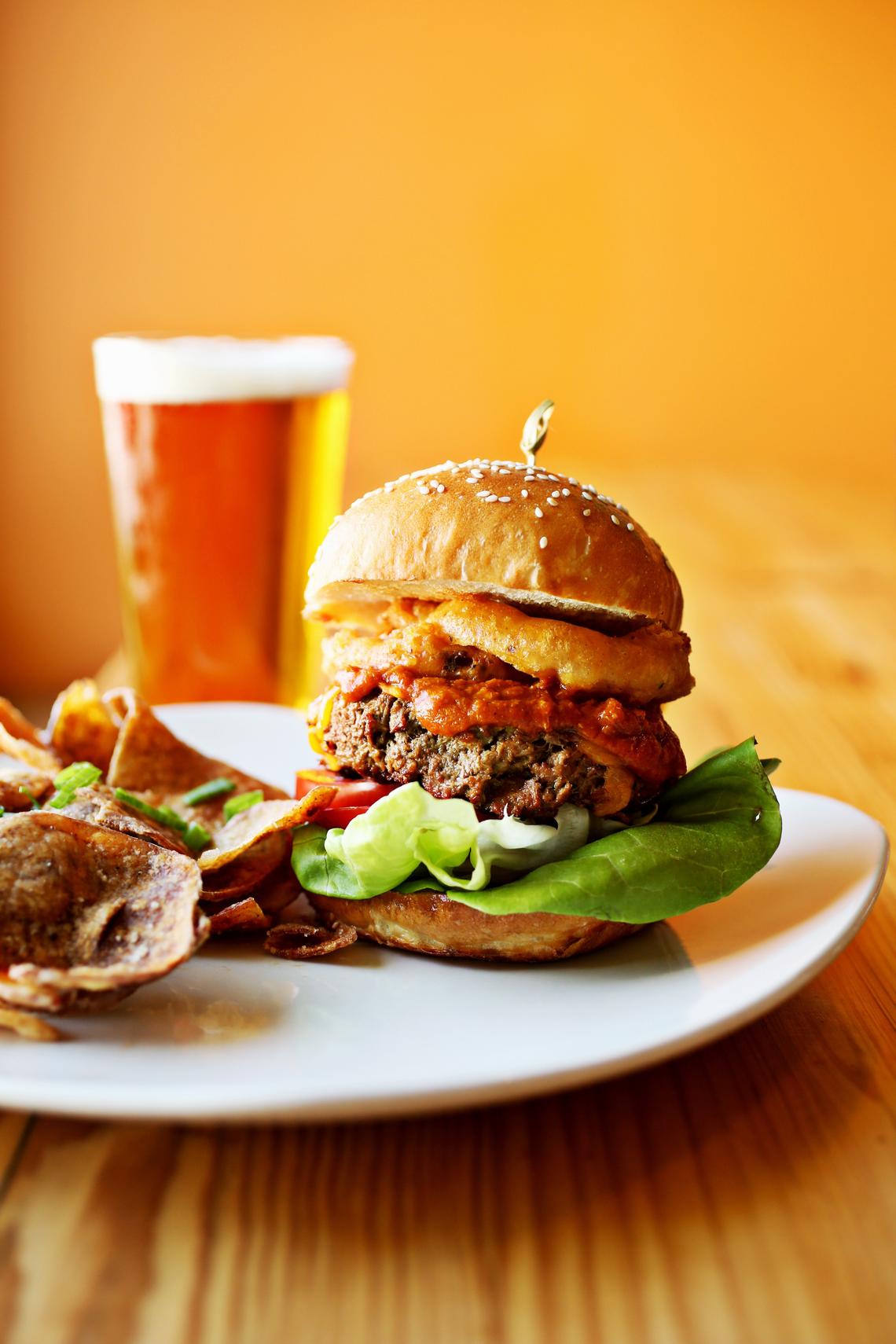 Fiction Kitchen serves 65 hand-patted and grilled “Impossible” burgers with a different theme every Thursday at the Raleigh restaurant. This version is on a Night Kitchen sesame bun topped with a housemade Green Man I.P.A. mustard, fried pickle onion rings, Hormel style chili, lettuce, tomato and housemade vegan cheddar served with hand-cut BBQ chips.