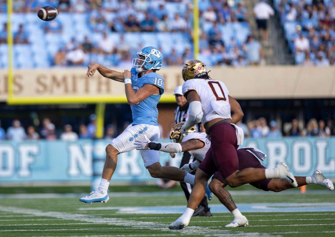 North Carolina quarterback Drake Maye (10) throws on the run, under pressure from Minnesota’s Devon Williams (9) in the fourth quarter on Saturday, September 16, 2023 at Kenan Stadium in Chapel Hill N.C.