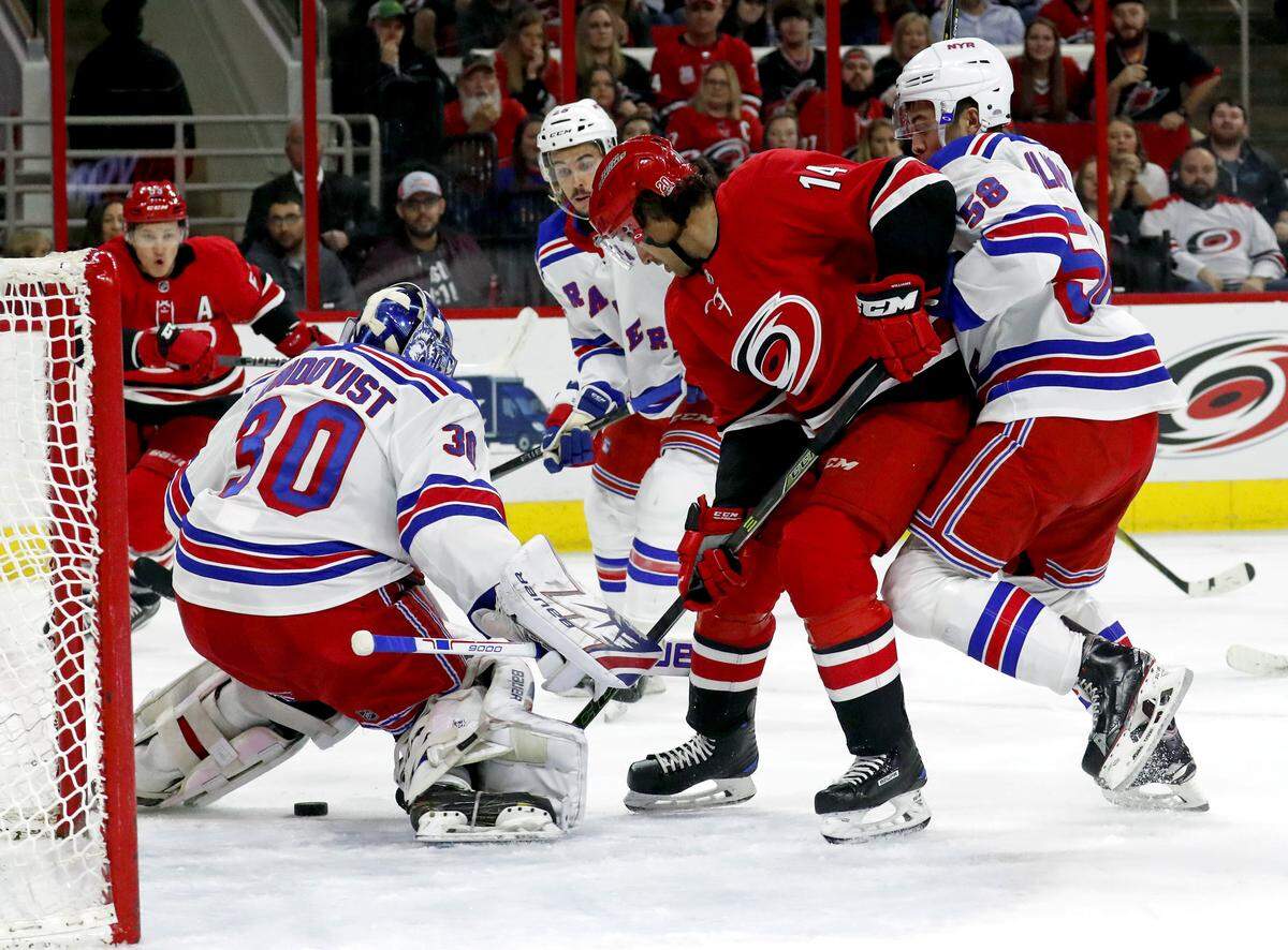 The Canes' Justin Williams (14) can't get the puck past the Rangers' Henrik Lundqvist (30) and John Gilmour (58) during the first period.  The Rangers beat the Canes 2-1..