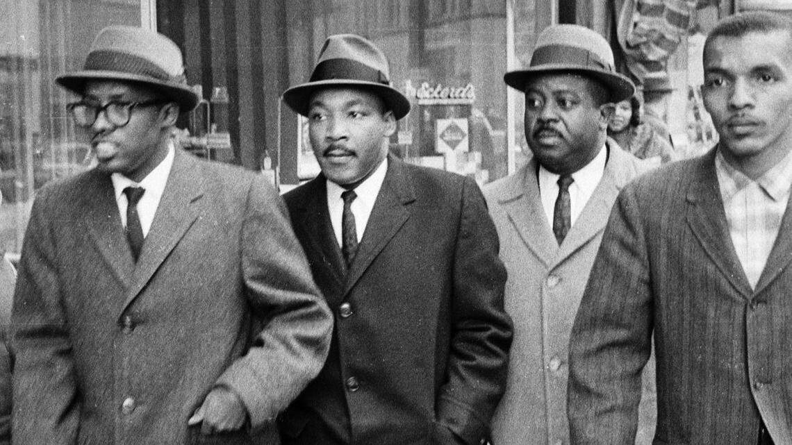 Rev, Douglas Moore, pastor of the Asbury Temple Methodist Church, Dr. Martin Luther King, Jr., Rev. Ralph David Abernathy and NCCU student Lacy Streeter walk along West Main Street on their way to the Woolworth Lunch Counter in this file photo of February 16,1960.