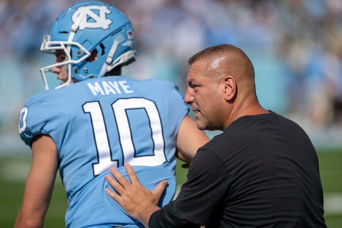 North Carolina offensive coordinator Phil Longo works with quarterback Drake Maye (10) prior to the Tar Heels’ game against Duke on Saturday, October 2, 2021 at Kenan Stadium in Chapel Hill, N.C.