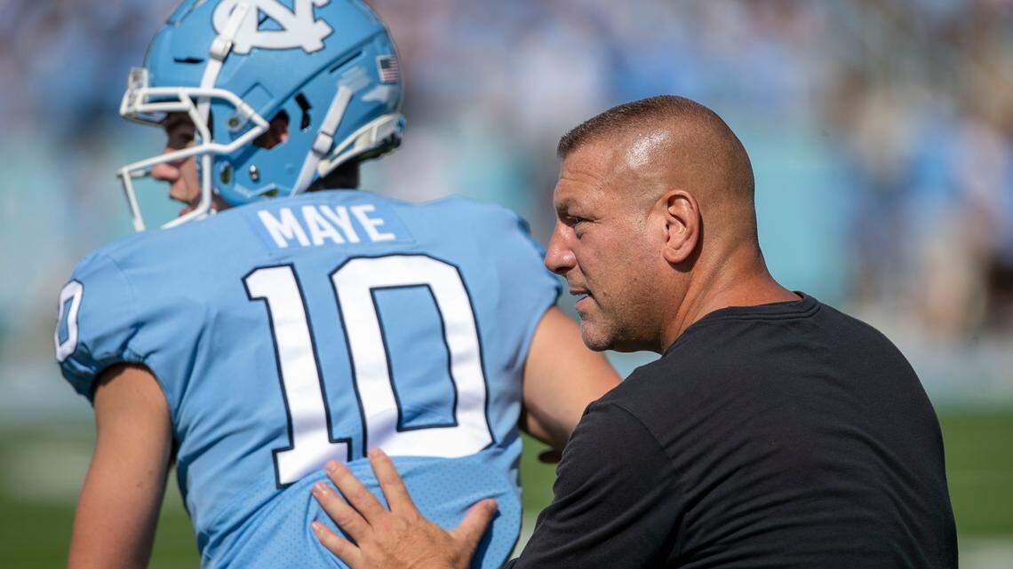 North Carolina offensive coordinator Phil Longo works with quarterback Drake Maye (10) prior to the Tar Heels’ game against Duke on Saturday, October 2, 2021 at Kenan Stadium in Chapel Hill, N.C.