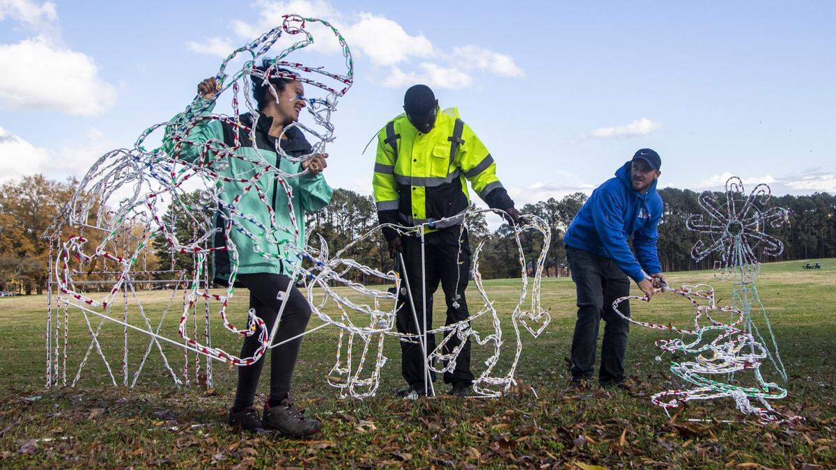From left, Iris Lloyd, Thomas Duke and Jesse Bartholomew install Christmas lights on a 1.3 mile route at Dorothea Dix Park. Monday, Nov. 30, 2020. The drive-thru holiday light show sponsored by WRAL in partnership with the City of Raleigh will operate nightly from Wednesday, Dec. 16, through Thursday, Dec. 31, 2020.