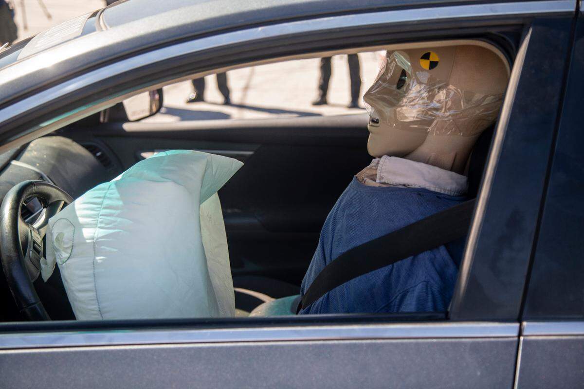 A crash test dummy sits in a Nissan Altima with a deployed airbag after a test of Cary engineer Aaron Kiefer’s prototype of a tractor trailer truck underride guard at N.C. State Highway Patrol test track Tuesday, Sept. 13, 2022. Keifer’s system is designed to prevent deadly side underride crashes.