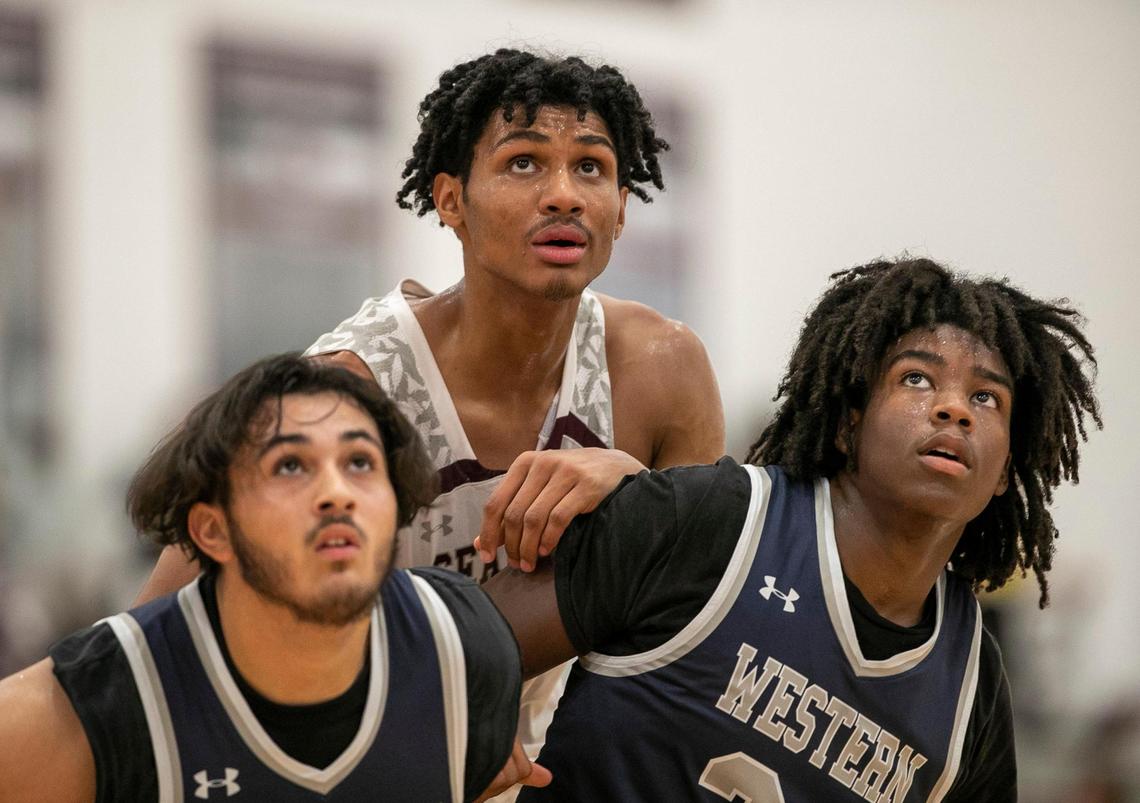 Western Alamance’s Nick McGhee (5) and Eliah Wade (24) box out Jarin Stevenson on a free-throw attempt during their game on Thursday, December 8, 2022 in Pittsboro, N.C.