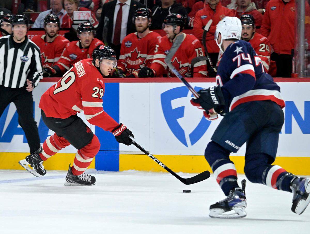 Team Canada forward Nathan MacKinnon (29) plays the puck and Team United States defenseman Jaccob Slavin (74) defends in the second period during a 4 Nations Face-Off ice hockey game at the Bell Centre.