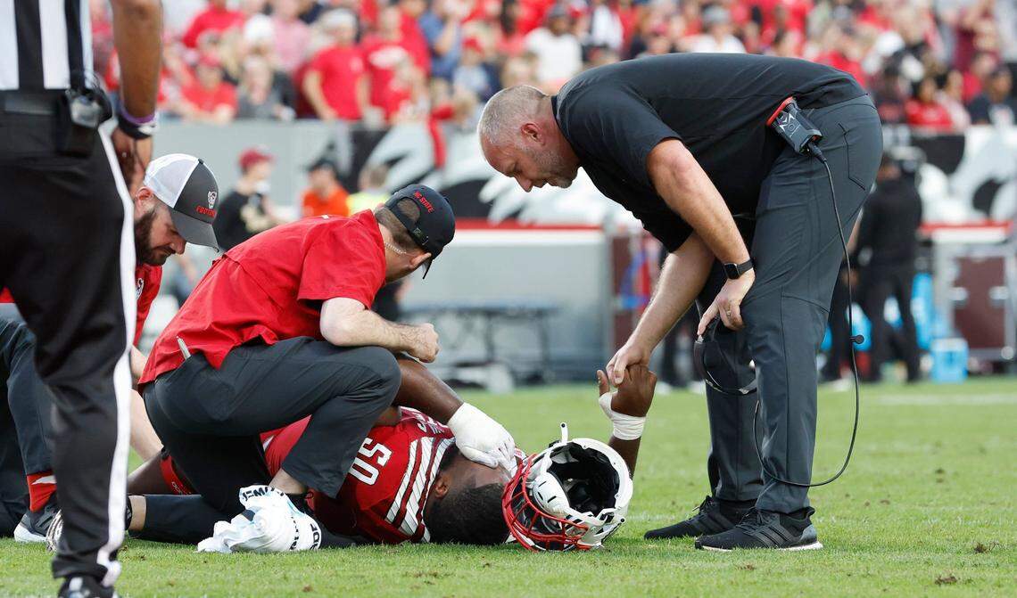 N.C. State head coach Dave Doeren checks on Grant Gibson (50) after he was injured during the first half of N.C. State’s game against Boston College at Carter-Finley Stadium in Raleigh, N.C., Saturday, Nov. 12, 2022.