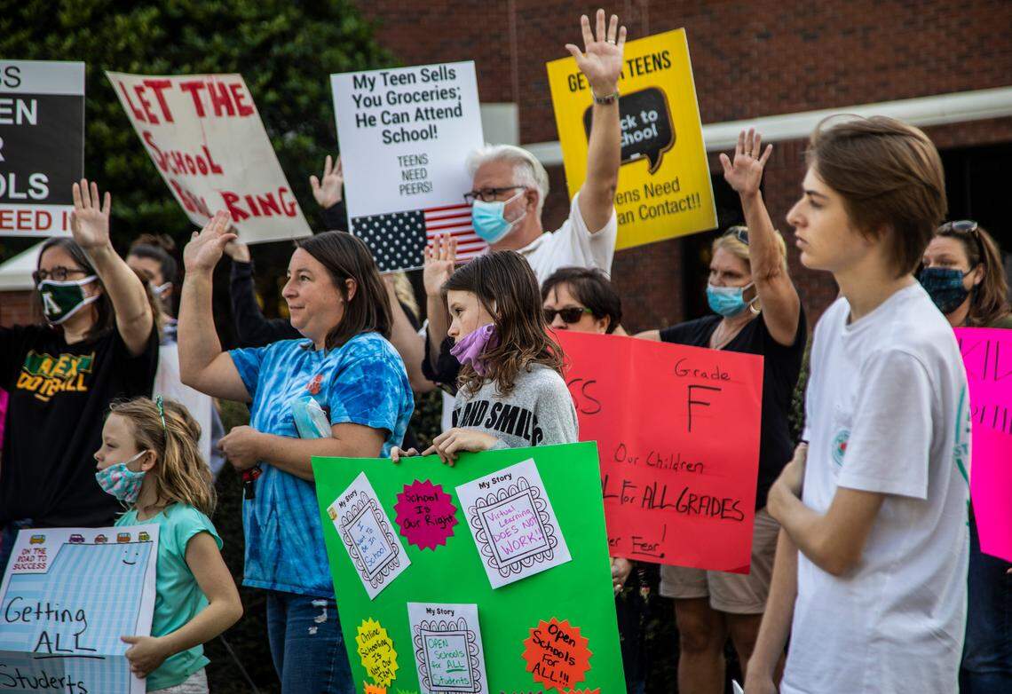 More than 100 people protest outside the Wake County school system’s headquarters Thursday, Oct. 1, 2020 against the plan to keep high school students on online class only into January.