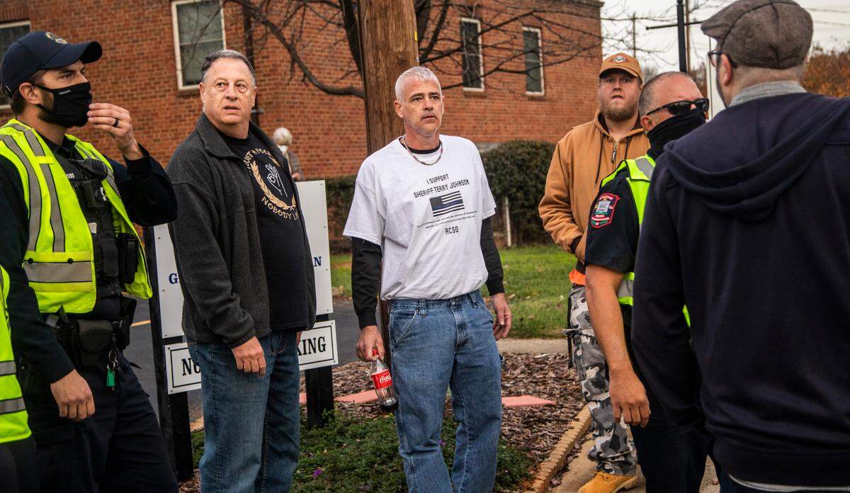 Thomas May, middle, wears a shirt on which he printed the words “I Support Sheriff Terry Johnson” while confronting protesters and Graham police officers during a demonstration on Nov. 29, 2020.