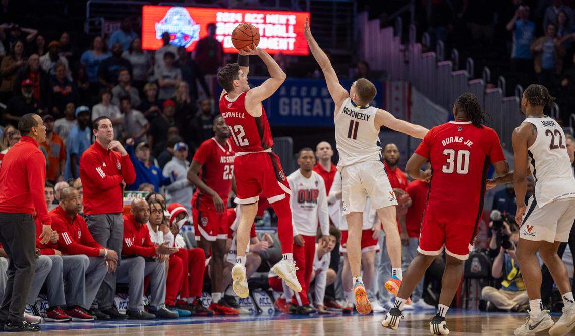 N.C. State’s Michael O’Connell (12) launches a three-point shot over Virginia’s Isaac McKneely (11) at the buzzer in regulation to tie Virginia 58-58 and force overtime during the semi-finals of the ACC Men’s Basketball Tournament at Capitol One Arena on Friday, March 15, 2024 in Washington, D.C.