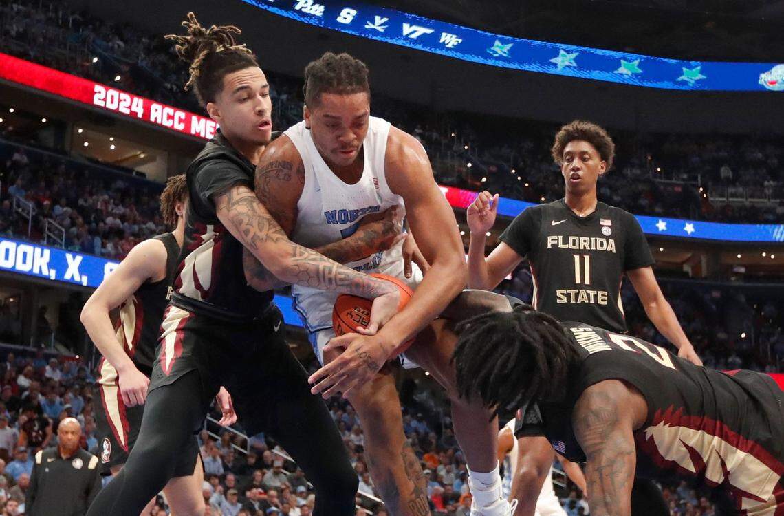 North Carolina’s Armando Bacot (5) keeps the ball from Florida State’s De’Ante Green (5) and Jamir Watkins (2) during UNC’s 92-67 victory over Florida State in the quarterfinal round of the 2024 ACC Men’s Basketball Tournament at Capital One Arena in Washington, D.C., Thursday, March 14, 2024.