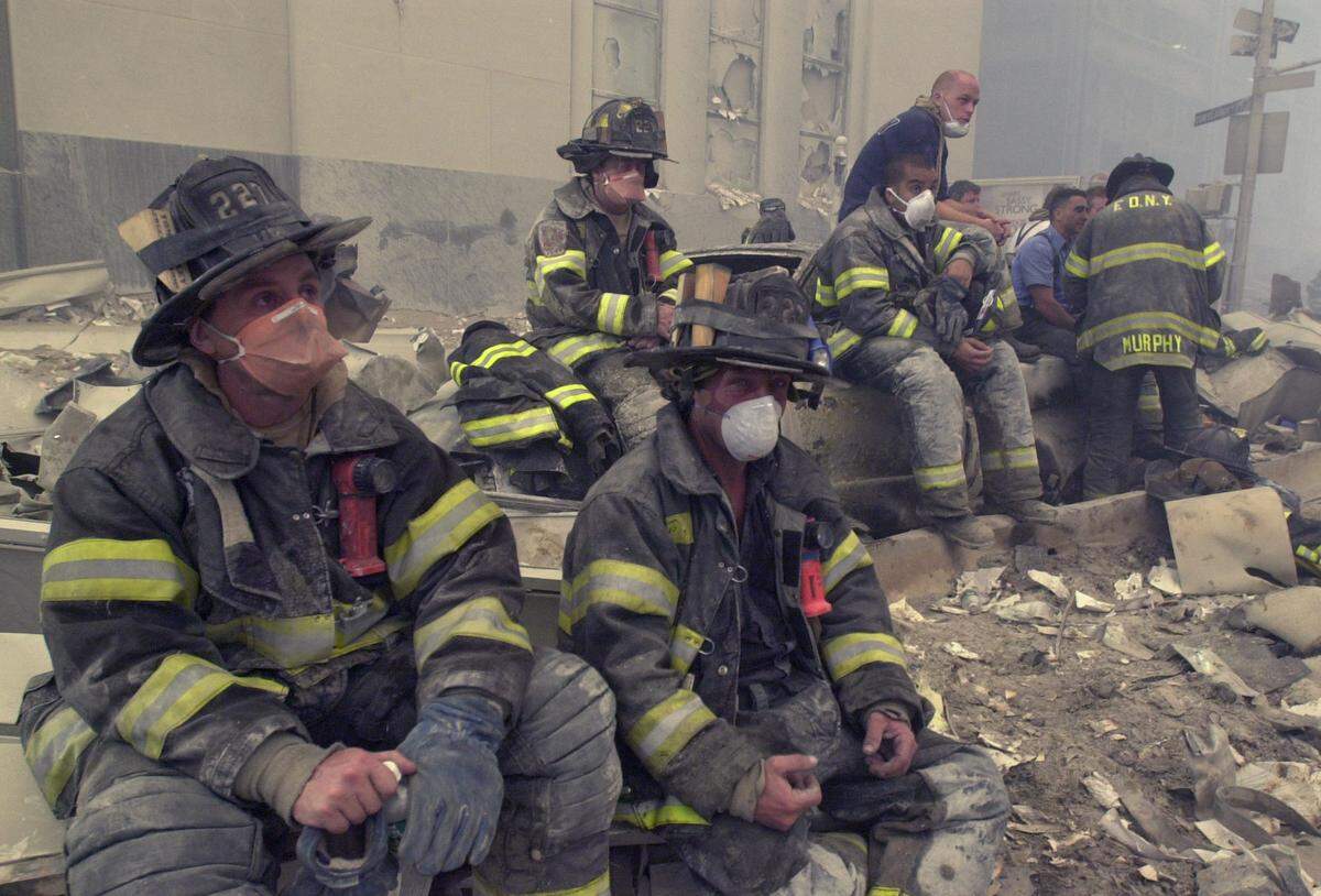 Firemen take a break near the site of the World Trade Center in New York, Wednesday, Sept. 12, 2001.