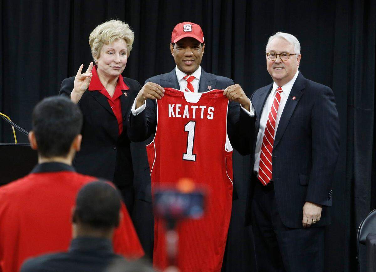 New N.C. State head men’s basketball coach Kevin Keatts, center, gets a hat and jersey from athletic director Debbie Yow, left, and Chancellor Randy Woodson during an introductory press conference at Reynolds Coliseum in Raleigh, N.C., Sunday, March 19, 2017.