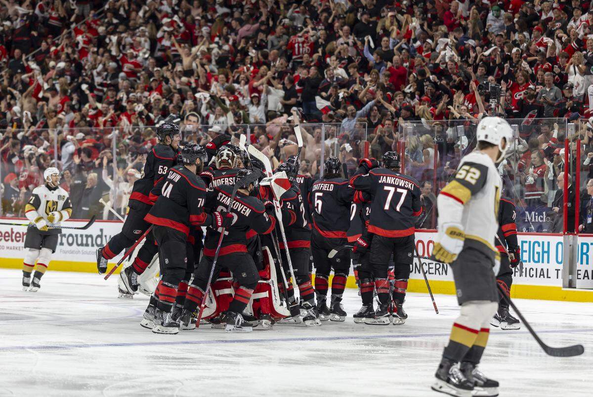 Carolina Hurricanes right wing Jackson Blake (53) jumps into the celebration at a mid-ice, after an overtime goal by Seth Jarvis (24) to secure a 4-3 victory over Vegas in Game 2 of the Stanley Cup Final, on Thursday, June 4, 2026 at Lenovo Center in Raleigh, N.C.