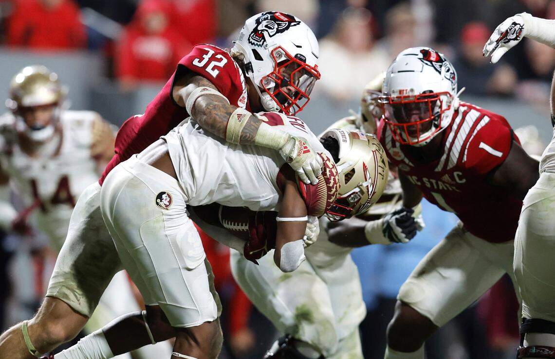 N.C. State’s Drake Thomas (32) and Isaiah Moore (1) stop Florida State running back Lawrance Toafili (9) during the second half of N.C. State’s 19-17 victory over Florida State at Carter-Finley Stadium in Raleigh, N.C., Saturday, Oct. 8, 2022.