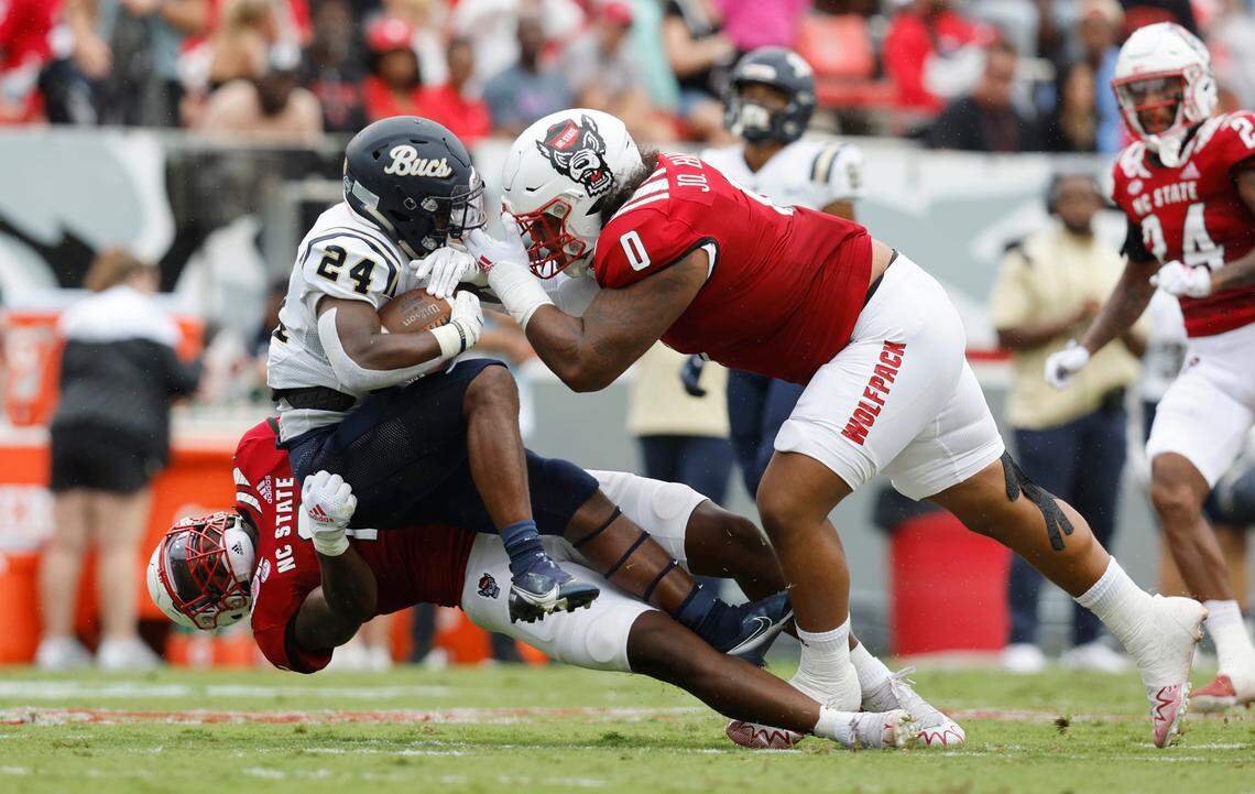 N.C. State linebacker Jaylon Scott (2) and defensive tackle Joshua Harris (0) stop Charleston Southern running back TJ Ruff (24) during the first half of N.C. State’s game against Charleston Southern at Carter-Finley Stadium in Raleigh, N.C., Saturday, Sept. 10, 2022.