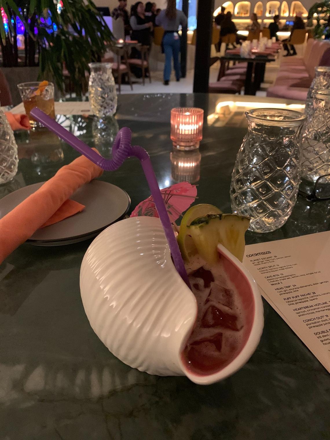 The cocktail list of tiki drinks as Aaktun includes the “Conch Out,” a vibrant punch served in a porcelain conch shell.