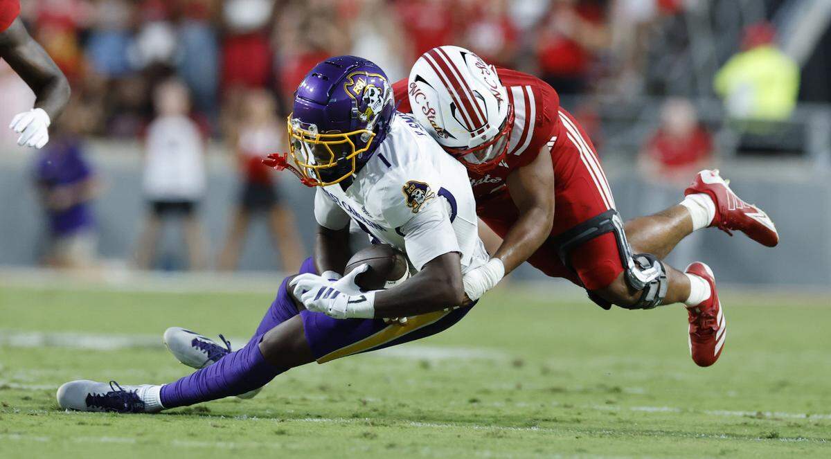 N.C. State defensive end Sabastian Harsh (54) tackles East Carolina wide receiver Yannick Smith (1) during the first half of N.C. State’s game against ECU at Carter-Finley Stadium in Raleigh, N.C., Thursday, Aug. 28, 2025.