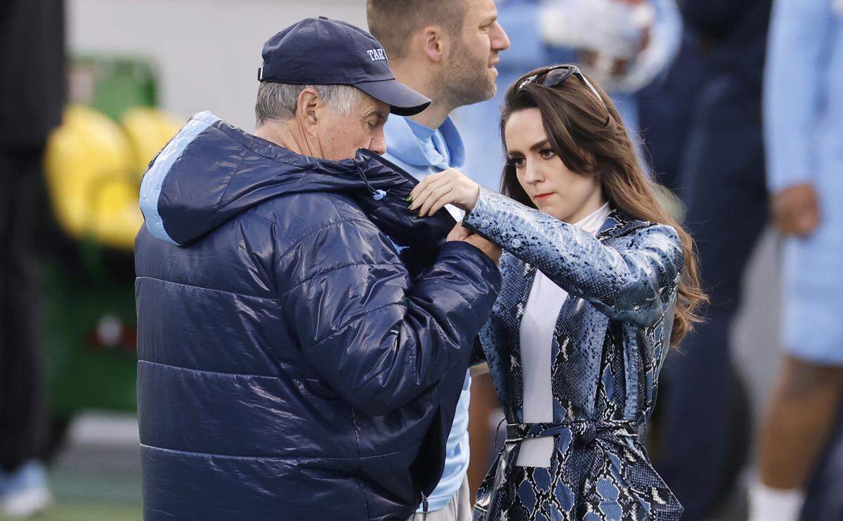 Jordon Hudson helps North Carolina head football coach Bill Belichick put on a mic before UNC football’s Practice Like a Pro open practice at Kenan Stadium in Chapel Hill, N.C., Saturday, April 12, 2025.