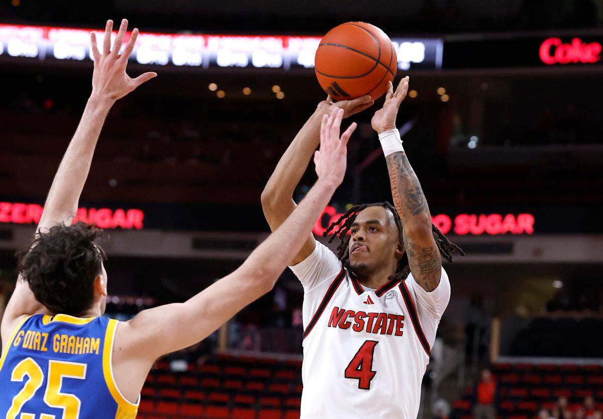 N.C. State’s Breon Pass (4) hits a three-pointer as Pittsburgh’s Guillermo Diaz Graham (25) defends during the first half of N.C. State’s game against Pitt at the Lenovo Center in Raleigh, N.C., Wednesday, March 5, 2025.