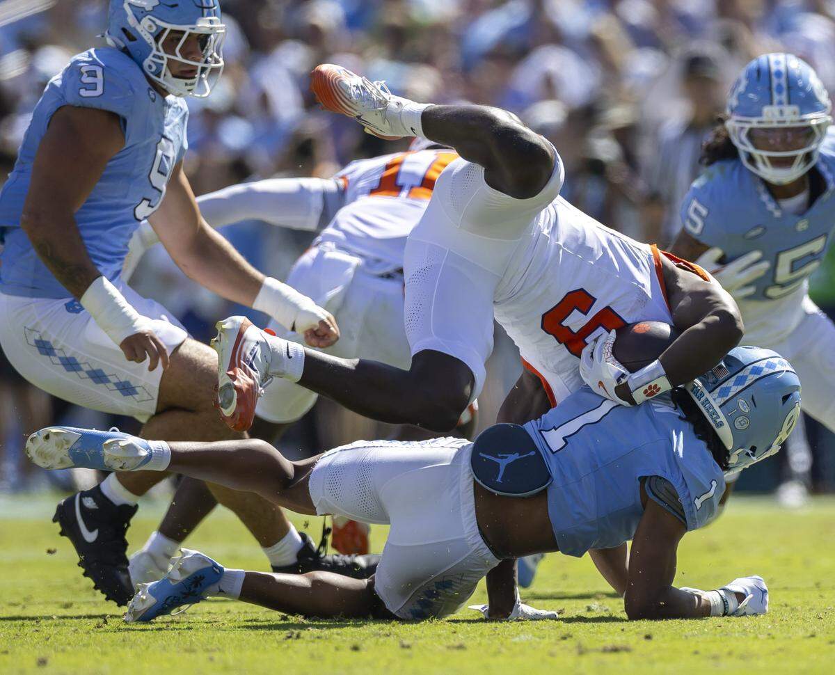 Clemson running back Gideon Davidson (9) is stopped for a four-yard loss by North Carolina cornerback Thaddeus Dixon (1) in the first quarter on Saturday, October 4, 2025 at Kenan Stadium in Chapel Hill, N.C. 