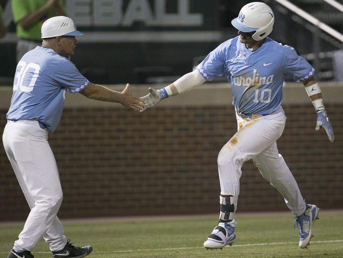 North Carolina coach Mike Fox greets North Carolina’s Zack Gahanna (10) as he rounds third base after connecting for a two run homer in the seventh inning against Houston during the NCAA Regional on Sunday, June 3, 2018 at Boshamer Stadium in Chapel Hill, N.C.