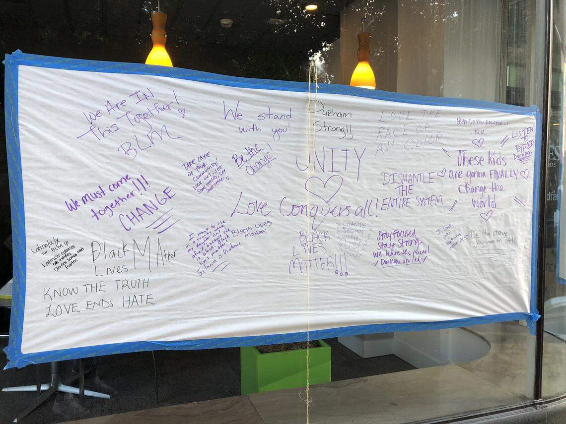 Protesters stop to sign these banners of support outside Durham Kress Condos on Main St. in downtown Durham, June 5, 2020. ÒWe are the Kress Community and we are listening,Ó one of the signs reads.