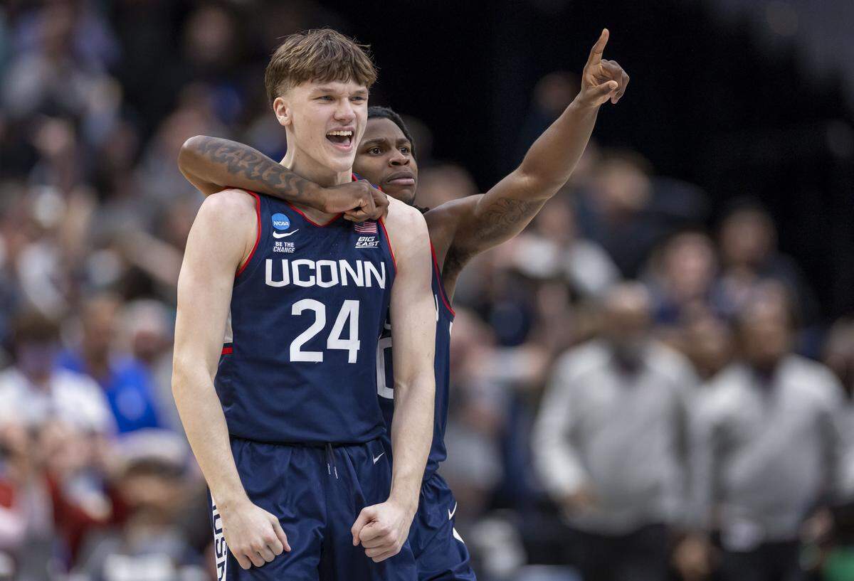 Connecticut guard Malachi Smith (0) embraces teammate Braylon Mullins (24), after Mullins hit the game winning three-point basket to secure the Huskies’ 73-72 victory over Duke on Sunday, March 29, 2026, in the NCAA East Regional Championship, at Capital One Arena in Washington, D.C.