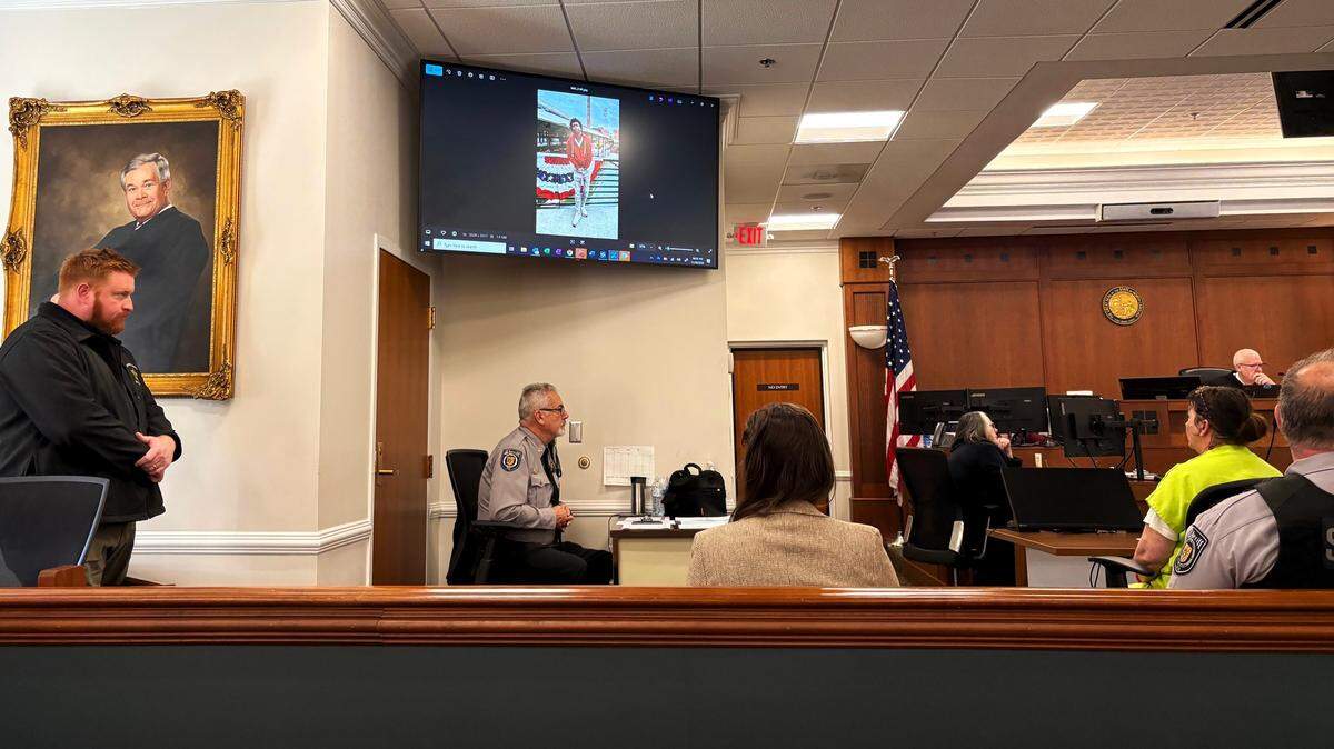 Monica Dove, 52, glances at a photo of Javontae “TJ” Brooks on a screen Tuesday, Nov. 18, 2025, in Orange County Superior Court. Dove’s gaze fell to the table in front of her when the photo was replaced with one of TJ hooked up to life support at Duke Hospital.