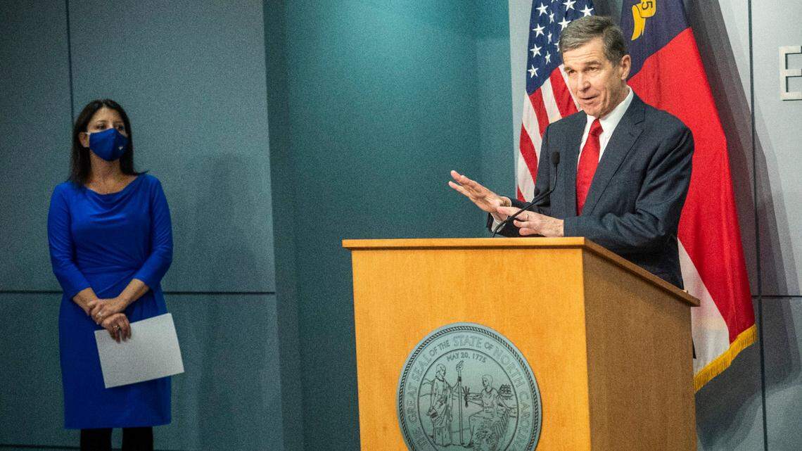 Gov. Roy Cooper speaks as Secretary of the NC Department Health and Human Services Dr. Mandy Cohen looks on during a briefing on North Carolina’s coronavirus pandemic response Wednesday, Sept. 30, 2020 at the NC Emergency Operations Center in Raleigh.