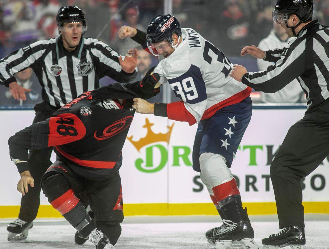 Washington Capitals’ Anthony Mantha (39) fights with Carolina Hurricanes’ Jordan Martinook (48) during the second period in the Stadium Series game on Saturday, February 18, 2022 at Carter-Finley Stadium in Raleigh, N.C