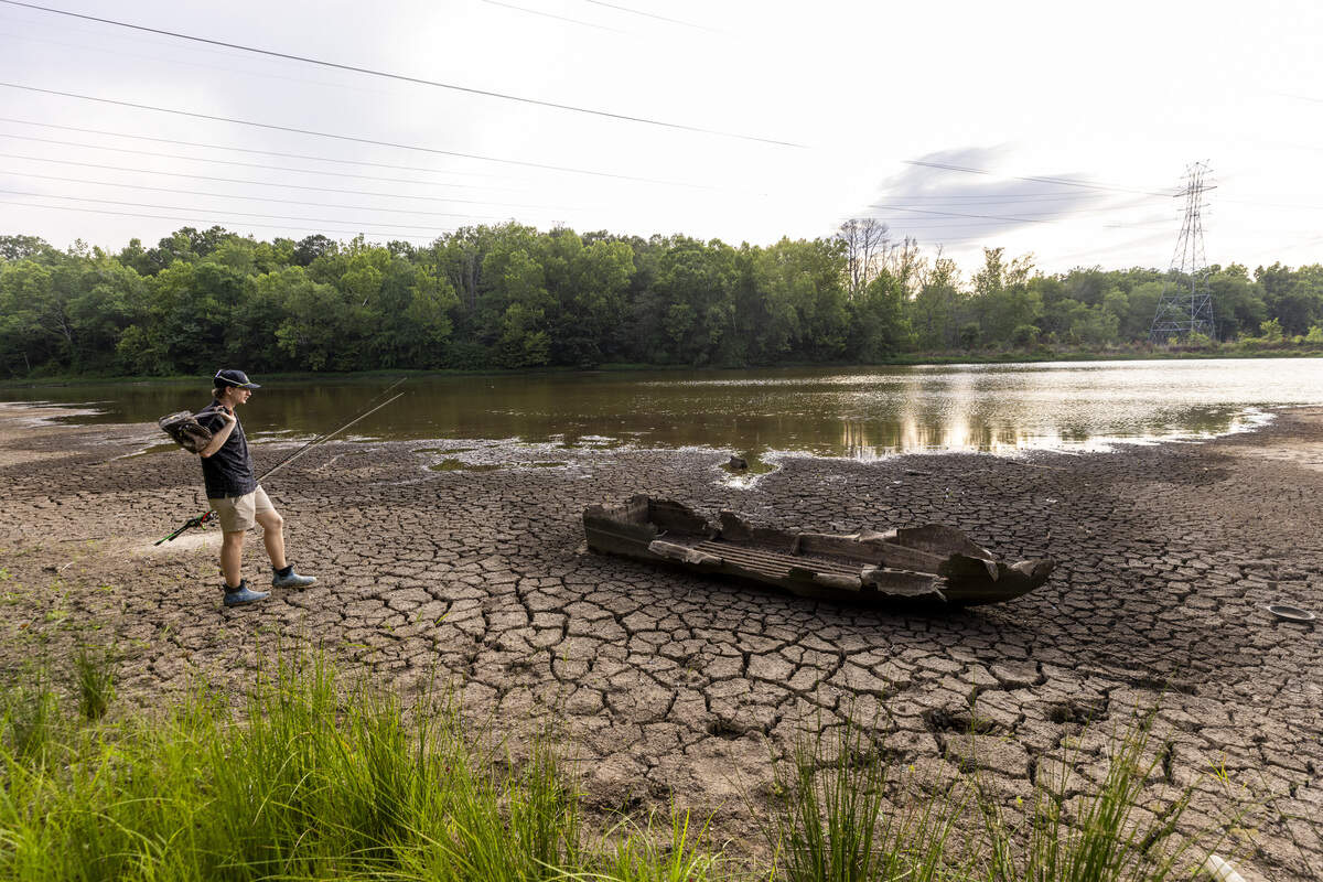 Connor Fox, 21, of Durham discovers the wreck of a small fishing boat on a partially exposed lake bed while fishing along the shoreline of Newcombs Lake on Friday, June 26, 2026. Raleigh is 18.59 inches below its average rainfall since August 2025, and Falls Lake, Raleigh's primary water source, is 5 feet below its target level. As of mid-June, Durham was about 10 to 12 inches below normal rainfall since the start of the year.