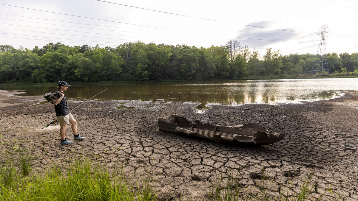 Connor Fox, 21, of Durham discovers the wreck of a small fishing boat on a partially exposed lake bed while fishing along the shoreline of Newcombs Lake on Friday, June 26, 2026. Raleigh is 18.59 inches below its average rainfall since August 2025, and Falls Lake, Raleigh's primary water source, is 5 feet below its target level. As of mid-June, Durham was about 10 to 12 inches below normal rainfall since the start of the year.