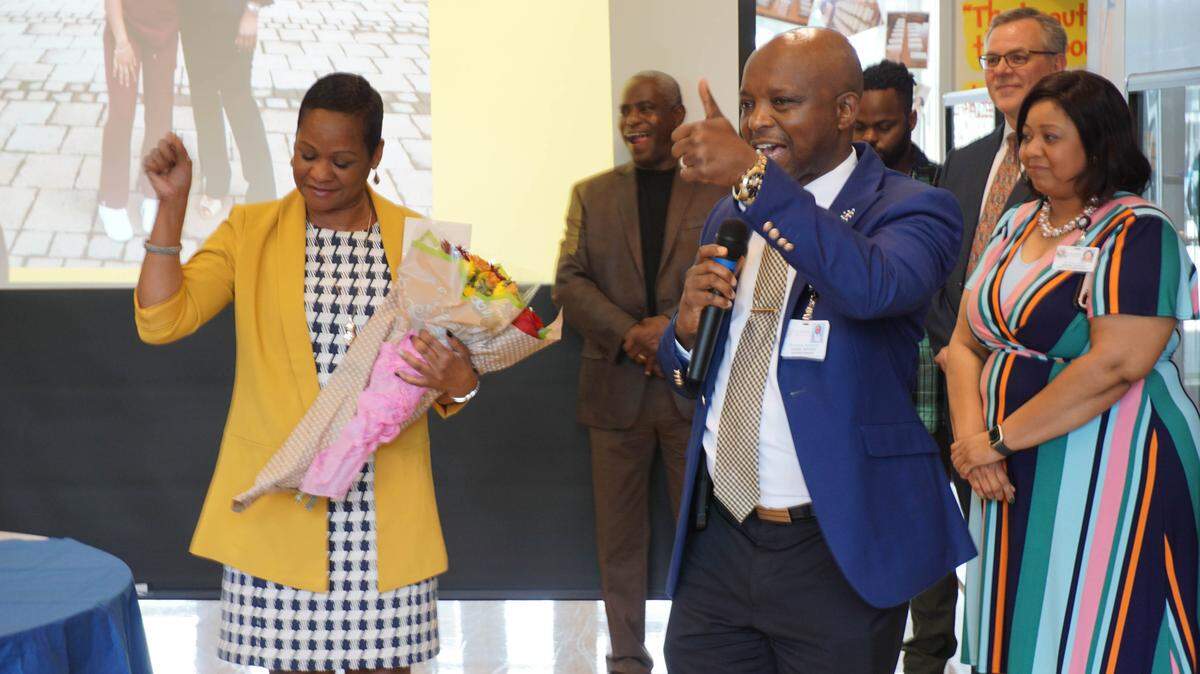 Jackie Tobias giving a fist pump while DPS Superintendent Pascal Mubenga gives a speech for the announcement that she had won DPS 2020 Principal of the Year.