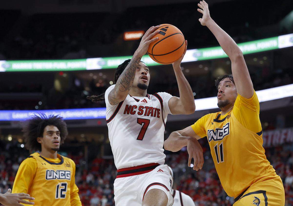 N.C. State’s Alyn Breed drives to the basket past UNC Greensboro’s Valentino Pinedo during the first half of the Wolfpack’s game on Wednesday, Nov. 12, 2025, at Lenovo Center in Raleigh, N.C.
